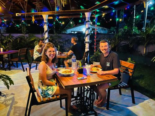 a man and woman sitting at a table at a restaurant at Star Eyes Hostel in Weligama