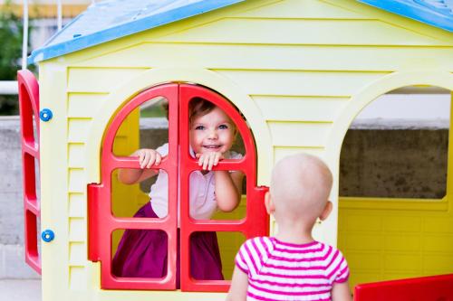 a little girl looking out of a window in a play house at Aphrodite Hotel in Zalakaros