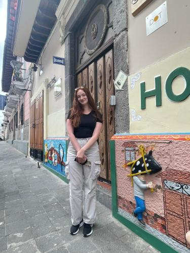 a woman standing in front of a building at Friends Hotel & Rooftop - Historic Center & Museums in Quito