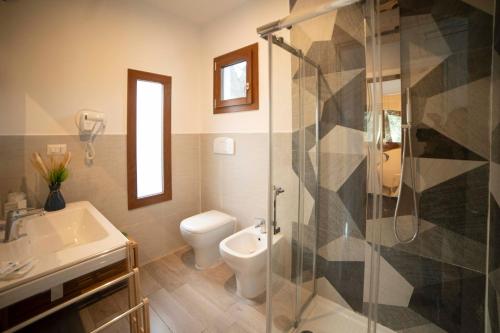 a bathroom with a shower and a toilet and a sink at saracena Holiday Home with Private Beach and Swimming Pool in Mattinata
