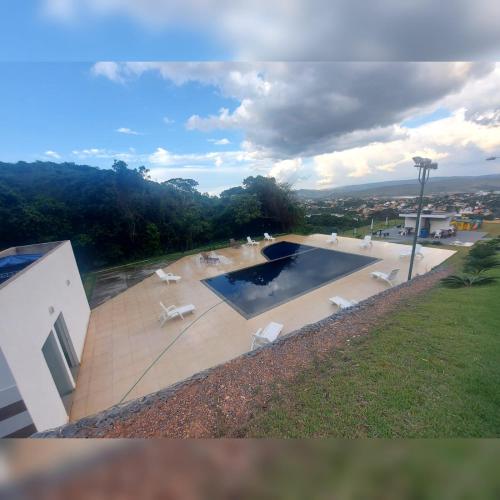 a view of a swimming pool with chairs on a house at Casa duplex em condomínio de alto padrão , localizado em escarpas do lago Capitólio MG in Capitólio