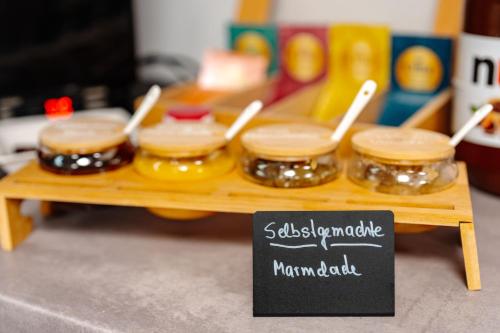 a tray with four jars of food on a table at Sonnenschein Hotel & Apartments in Heilbad Heiligenstadt