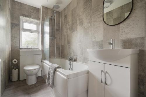 a bathroom with a sink toilet and a mirror at St Abbs - Beautiful Home, EV, parking, garden in Hull