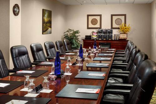 a conference room with a long table and chairs at APA Hotel Woodbridge in Iselin