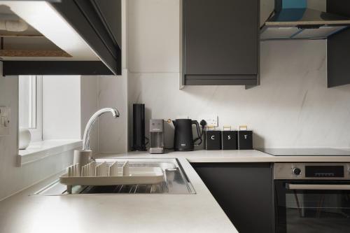 a kitchen with a sink and a counter top at St Abbs - Beautiful Home, EV, parking, garden in Hull