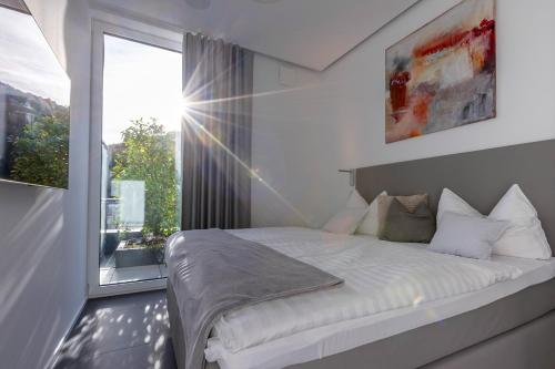 Un dormitorio con una cama y una ventana grande. en Neu PENTHOUSE MoselTop Luxus Design Klima 2P, en Traben-Trarbach