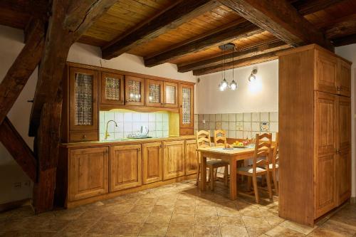 a kitchen with wooden cabinets and a table with chairs at Vincent OldTown Apartments in Wrocław