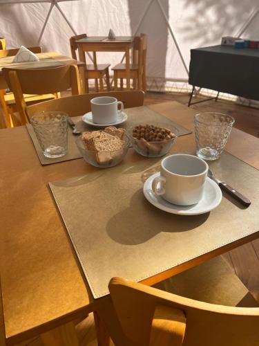 een tafel met kommen met noten en kopjes erop bij FITZ CAMP - Glamping agreste - Base Cerro Fitz Roy in El Chalten