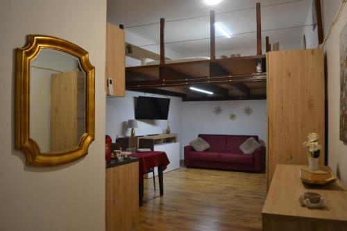 a living room with a red couch and a mirror at La dimora di Alice in Sassari