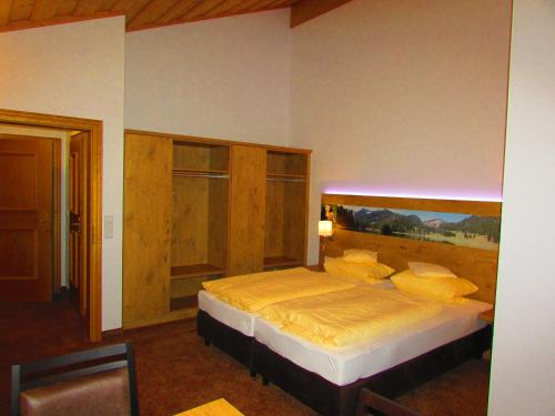 ein Schlafzimmer mit einem Bett mit einem hölzernen Kopfteil in der Unterkunft Gästehaus Gritscher in Josefsthal