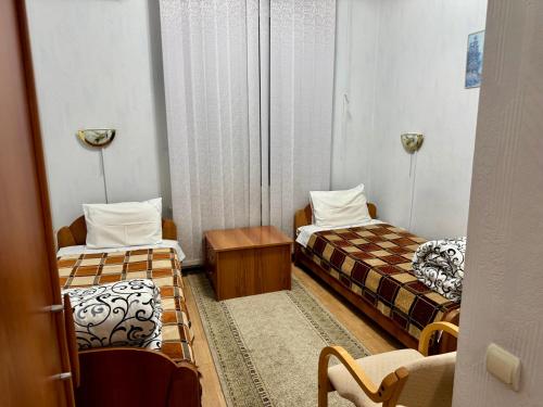 a small room with two beds and a chair at Hotel Anastasia in Rezina
