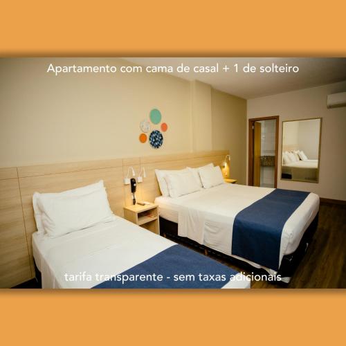 two beds in a hotel room with at Luds Comfort Hotel in Ponta Grossa