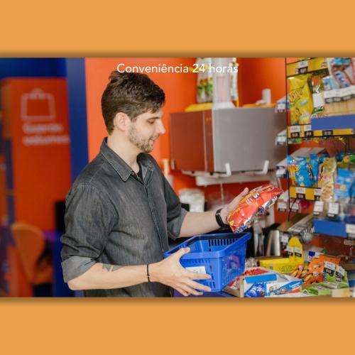 a man holding a shopping basket in a store at Luds Comfort Hotel in Ponta Grossa