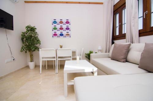 a living room with a white couch and a table at Apartamentos Centro Puerto de Santa Maria in El Puerto de Santa María