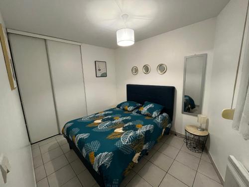 une chambre avec un lit avec une couette bleue dans l'établissement Le Roch - T3 Cosy & Spacieux, à Amiens