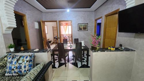a living room with a dining table and a television at Appartement C à 7 min de l’aéroport de Marrakech in Marrakech