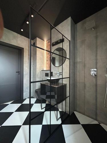 a bathroom with a black and white checkered floor at Apartament Garden in Leszno