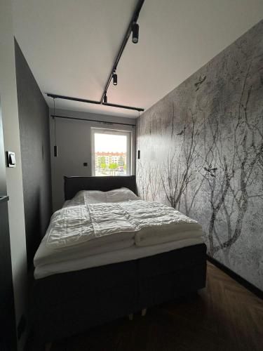 a bedroom with a bed in a room with a window at Apartament Garden in Leszno