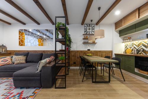 a living room with a couch and a table at Двокімнатний апартамент на увесь перший поверх котеджу Freeman-3а - це ЧАСТИНА БУДИНКУ з окремим входом - є камін, велика тераса, гриль in Bukovel