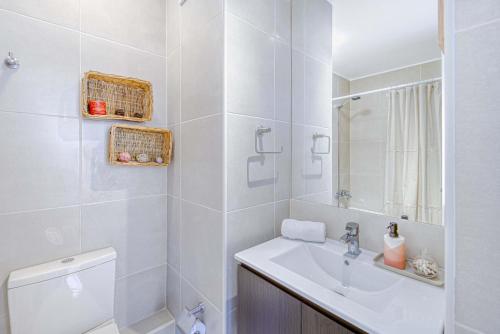 a white bathroom with a sink and a toilet at Vista Infinita in Concón