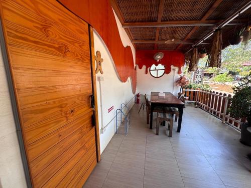 a wooden door of a house with a table on a porch at Lala Villa Koh Larn in Ko Larn