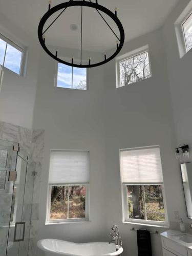 a bathroom with a chandelier and a shower and a sink at Gator Grove - Queen Ann White - New Build! in Gainesville
