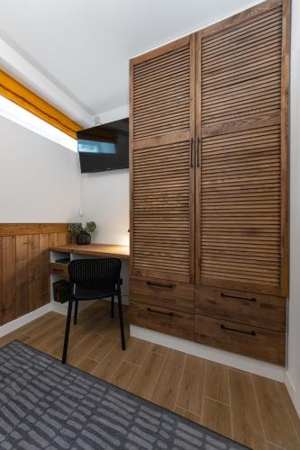 a room with a large wooden cabinet and a chair at Двокімнатний апартамент на увесь перший поверх котеджу Freeman-3а - це ЧАСТИНА БУДИНКУ з окремим входом - є камін, велика тераса, гриль in Bukovel