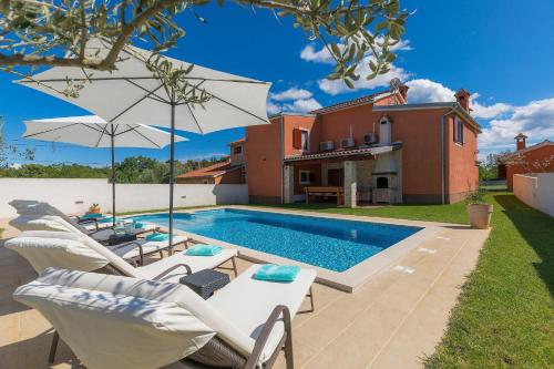 a villa with a swimming pool and a house at Villa Prisedi in Rakalj
