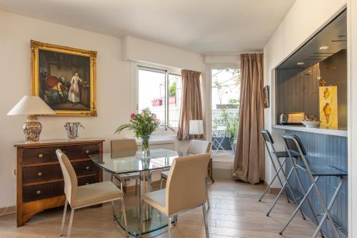 une salle à manger avec une table et des chaises en verre dans l'établissement Veeve - Panoramic Views from the 17th, à Paris