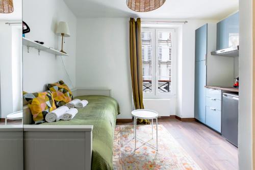 un petit appartement avec un canapé vert dans une pièce dans l'établissement Studio refait à neuf 2 pers Bastille - Oberkampf, à Paris