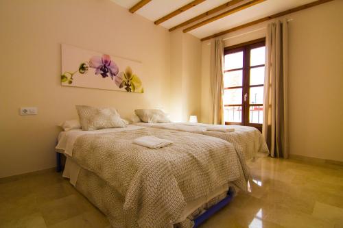 a bedroom with a bed and a window in it at Apartamentos Centro Puerto de Santa Maria in El Puerto de Santa María