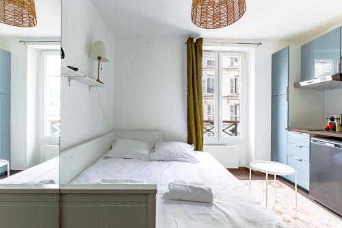 une petite chambre avec un lit et une cuisine dans l'établissement Studio refait à neuf 2 pers Bastille - Oberkampf, à Paris