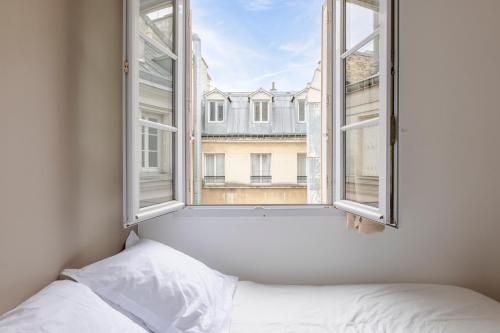 - une chambre avec un lit et une fenêtre ouverte dans l'établissement Veeve - Earthy Serenity, à Paris