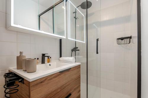 une salle de bain avec un lavabo et une douche dans l'établissement Veeve - Earthy Serenity, à Paris