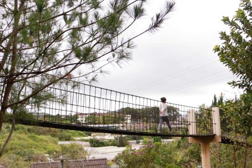 a person walking across a suspension bridge at Otel Hotel Dalat in Da Lat