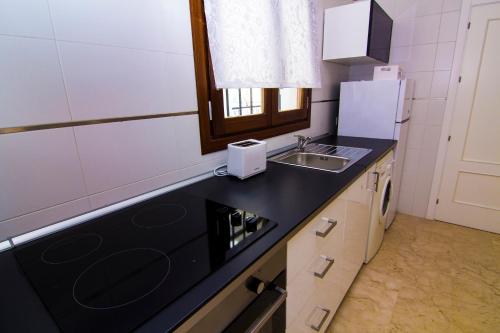 a small kitchen with a sink and a microwave at Apartamentos Centro Puerto de Santa Maria in El Puerto de Santa María