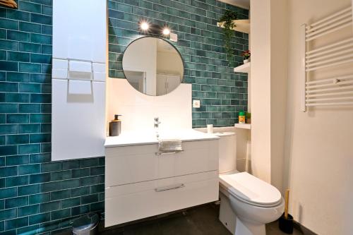 une salle de bain avec toilettes et miroir dans l'établissement La Parenthèse Choletaise - Sérénité en Centre-Ville, à Cholet