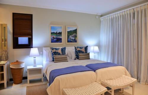 a bedroom with a large bed with blue sheets and pillows at Eden Island Luxury Accommodation in Eden Island
