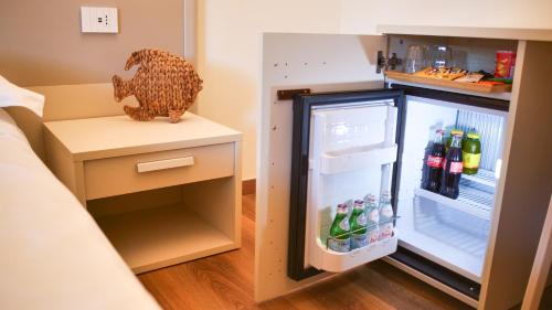 a small kitchen with an open refrigerator at Rex Hotel Residence in Genova