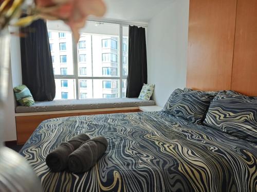 a bed with two pairs of shoes laying on it at City comfort appartment, Skytain Step 600 m, Erawan shrine in Bang Kapi