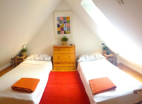 a attic room with two beds and a dresser at Chalet Floranneve in Bovec