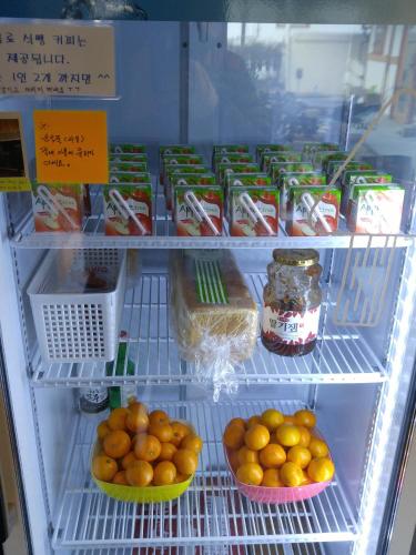 a refrigerator filled with lots of oranges and other food at Jeonju Tosarang Guesthouse in Jeonju