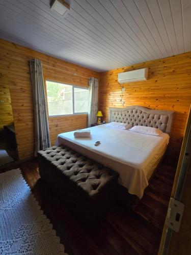 a bedroom with a large bed and a window at Casa Rústica Iguaçu in Foz do Iguaçu