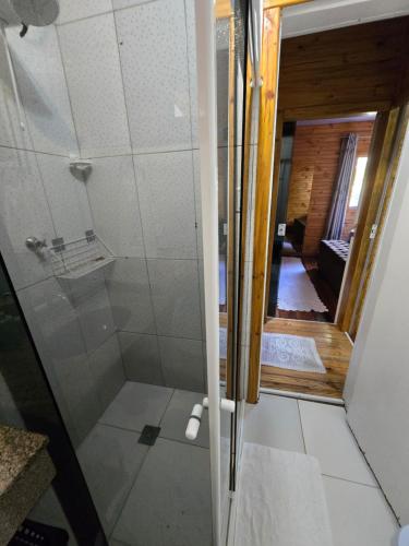 una ducha con puerta de cristal en un baño en Casa Rústica Iguaçu, en Foz do Iguaçu