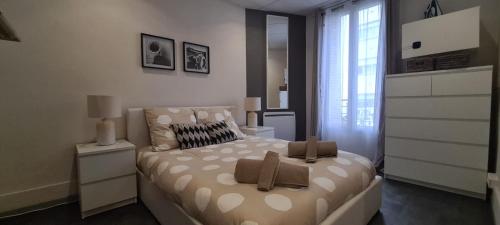 une chambre avec un lit avec des oreillers dessus dans l'établissement L'Urban Clignancourt - Bel appartement tout équipé aux Portes de Paris, à Saint-Ouen