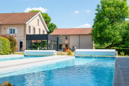 une piscine devant une maison dans l'établissement L'Artbanne - Le domaine, à Saint-Hilaire-le-Petit