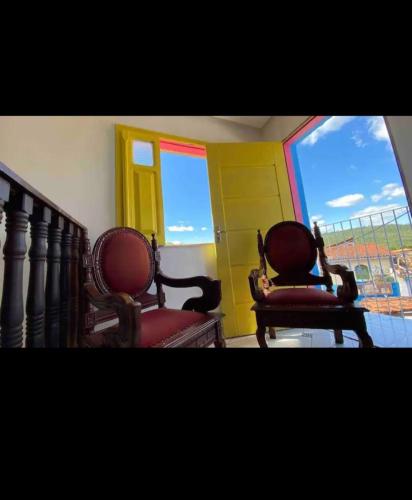 two chairs sitting in a room with a window at Casa my House in Lençóis