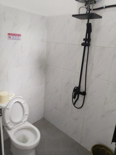a bathroom with a toilet with a camera on the wall at Vila Alief Batu in Tlekung