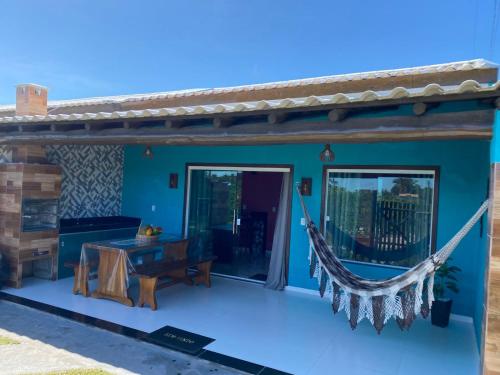 a blue house with a hammock on a patio at Recanto das Oliveiras in Corumbau