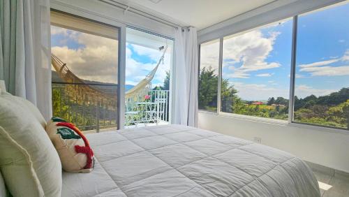 a bedroom with a bed and a large window at Casa Reina by Villa Alejandro in Boquete